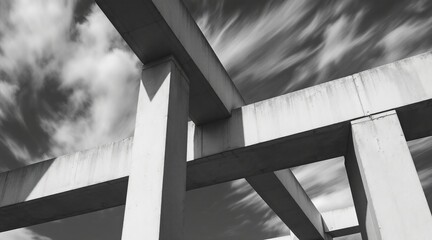 Abstract black and white shot of concrete beams against a cloudy sky creates a stark architectural composition