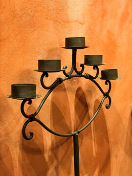 Shadows From Iron Candelabra Against Wall