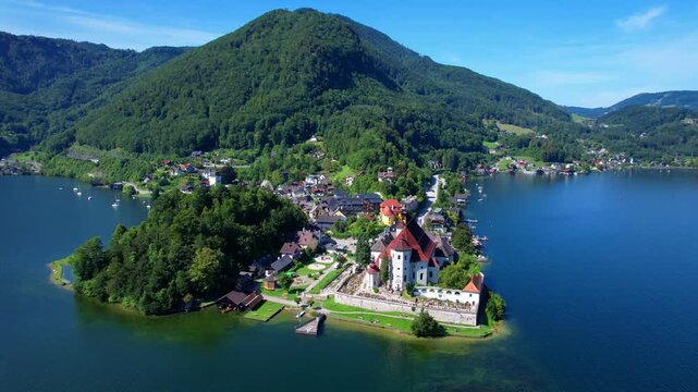 Austria Traunkirchen Aerial 4K Video Scenic Peninsula with Monastery and Church on Traunsee Lake Shore Colorful Houses and Alps Mountains Background Beautiful Salzkammergut Region Travel View