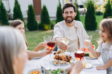 Family Enjoying Outdoor Dinner with Toasts