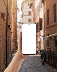 Smartphone with blank screen held in hand on European street background