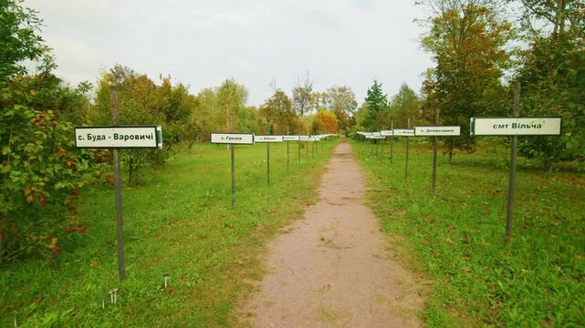 A poignant view of the memorial path in the Chernobyl Exclusion Zone, featuring signs bearing the names of villages evacuated after the 1986 nuclear disaster.
