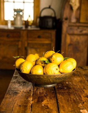 A bowl of lemons on a rustic wooden table
