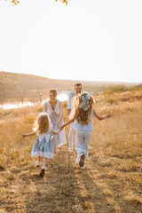  happy family having fun with two children in blue clothes on nature