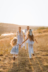 Fototapeta premium happy family having fun with two children in blue clothes on nature