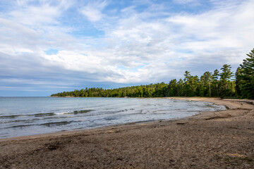 Katherine Cove offers a tranquil escape with its pristine sandy shores and lush forest backdrop along Lake Superior.