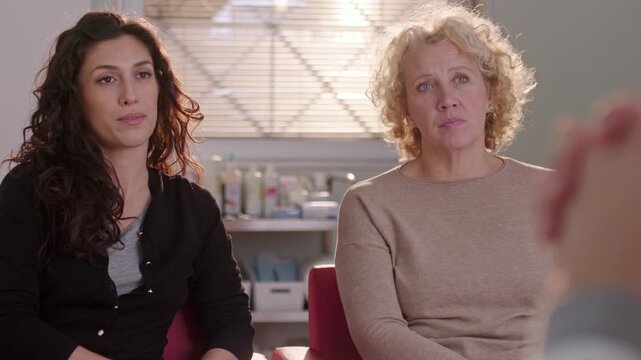 Two women in a professional setting having a serious conversation.