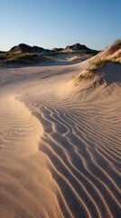 Sand dunes under a clear sky at sunset