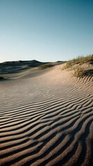 Patterns of sand dunes under the clear blue sky