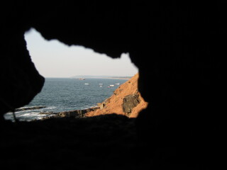 Coastal view through rock formation overlooking the ocean waves  