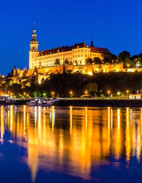 A castle at night, reflected on the water
