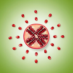 Fototapeta premium Pomegranate Sun: A Half-Cut Fruit with Seeds Radiating on a Green Background