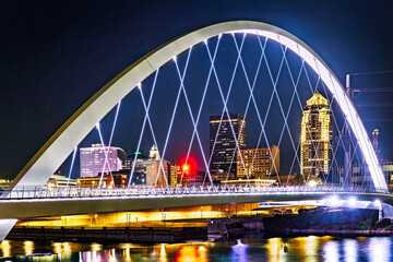 Des Moines, Iowa skyline by night, framed by the Principal Riverwalk bridge. Des Moines is the capital and most populous city in the U.S. state of Iowa and seat of Polk County