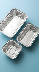 Three shiny aluminum foil containers on light blue background
