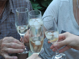 glasses in the hands of people on vacation with a drink