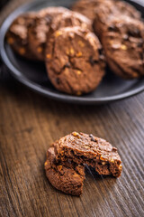 Sweet chocolate cookies on wooden table.