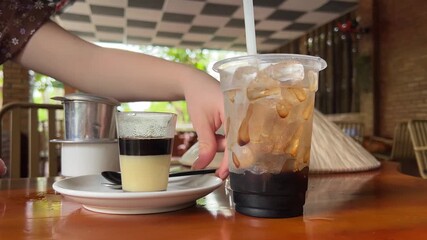the process of making vietnamese coffee with condensed milk Making Vietnamese coffee with condensed milk in a traditional filter on a table in a cafe slow motion close-up