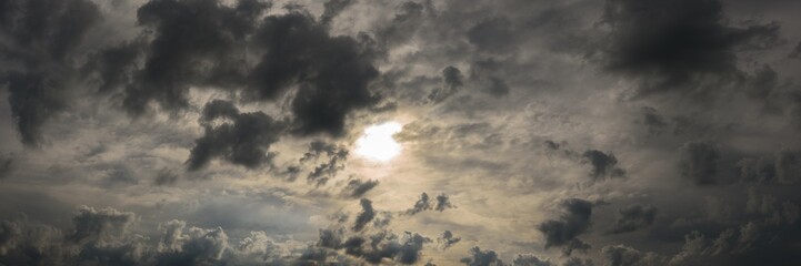 dramatic stormy sky with dark clouds, dense atmospheric haze and bright sunlight shining through....
