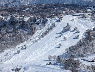 High angle view of snowy slopes and chairlifts at Madarao ski resort in Nagano, Japan