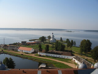 Scenic view of tranquil lake with church and village in summer  