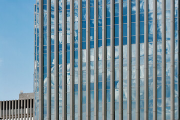 Obraz premium Upward angle view of a modern glass office building with rooftop ventilation and antennas in Saskatoon, Canada.
