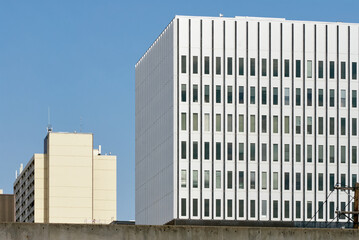 Angled side view of a tall white office building with rows of windows in downtown Saskatoon, Canada.