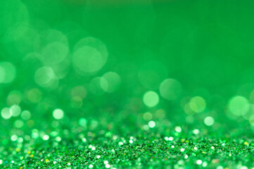 Bright green glitter shines under soft light creating a vibrant background effect