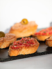 Crispy Spanish tapas with tomatoes and tuna pate close up