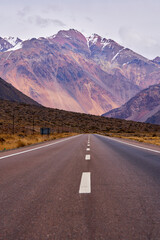 mountain road landscape with snowy peaks in the background
