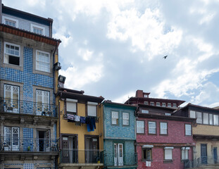 Traditional colorful facades with balconies in the Ribeira district in Porto, showcasing typical Portuguese architecture under a cloudy sky
