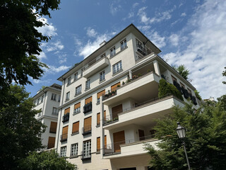 Saniertes, urbanes Stadthaus mit gro&szlig;en Fenstern und Balkonen im Gr&uuml;nen in M&uuml;nchen