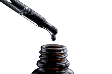 A single drop of clear liquid falls from a glass pipette into a dark amber bottle against a transparent background. background removed
