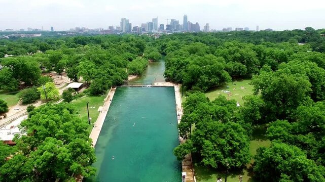Aerial view of barton springs pool and zilker park with austin skyline in texas