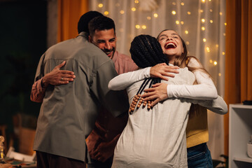 Happy friends embracing each other at home party