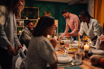 Friends preparing thanksgiving dinner table at home