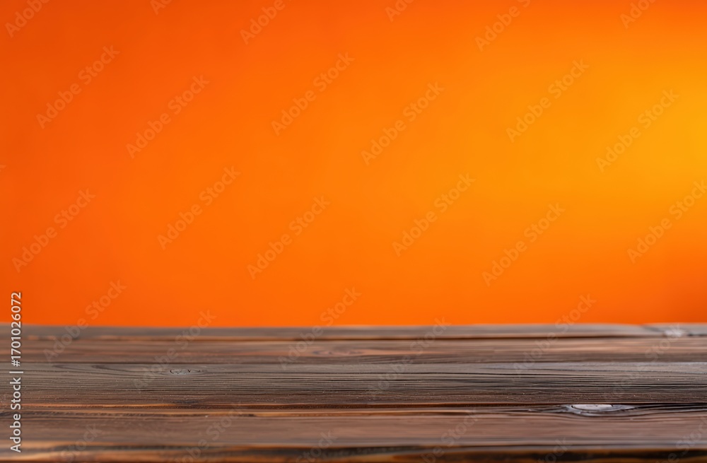 Poster empty wooden tabletop set against a vibrant orange background, creating an ideal surface for showcas
