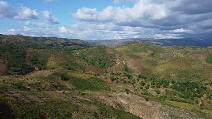 Picturesque view of a green valley with rolling hills and a cloudy sky on a bright sunny day landscape - Powered by Adobe