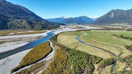 Surrounded by mountain ranges the Turiwhate River flows through farming fields on the road to Arthurs Pass