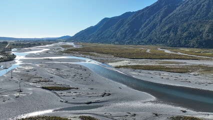 Surrounded by mountain ranges the Turiwhate River flows through farming fields on the road to Arthurs Pass