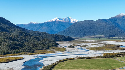 Surrounded by mountain ranges the Turiwhate River flows through farming fields on the road to Arthurs Pass