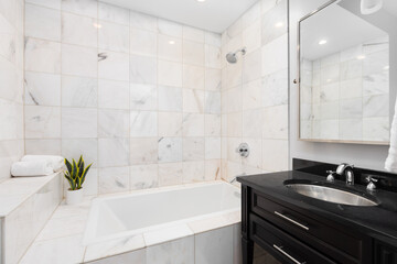 A bathroom with a dark wood vanity cabinet, stainless steel sink, chrome faucet, and a shower and...