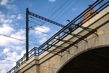 A sturdy bridge featuring a protective railing with a vivid blue sky serving as a beautiful background, creating a picturesque scene