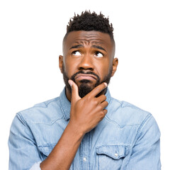 A pensive young Black man with a beard, hand on chin, looks thoughtfully upward. background removed