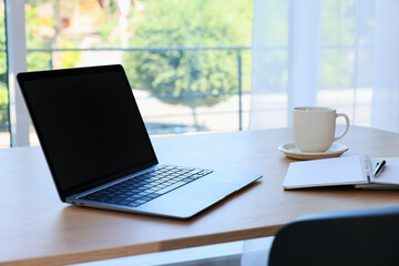 Fototapeta premium Home workspace. Modern laptop and stationery on wooden desk indoors