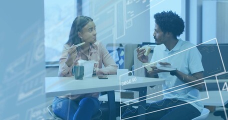 Talking coworkers using chopsticks and eating sandwich at office lunch table, with mug smartphone