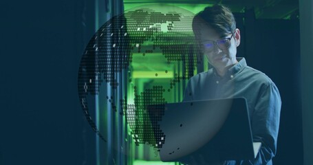 IT technician examining laptop screen in server rack corridor, with floating digital globe