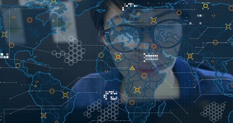 Chinese woman wearing glasses, blue shirt analyzing digital interface in tech office, map overlay