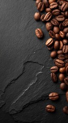 Coffee beans scattered on a dark stone surface