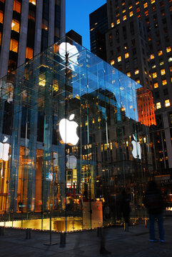 The entrance to the Apple store in New York City is inside a glass lobby that leads underground and is illuminated at night