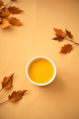 Enjoy golden fall flavors with soothing pumpkin soup served with autumn leaves on a warm beige table